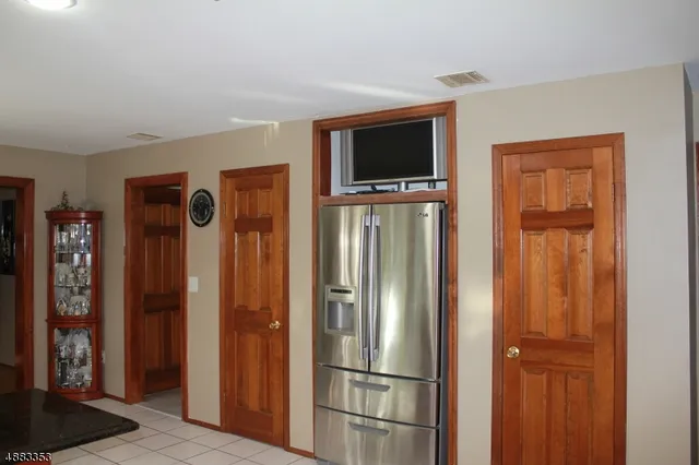 a kitchen with stainless steel appliances a refrigerator and a television