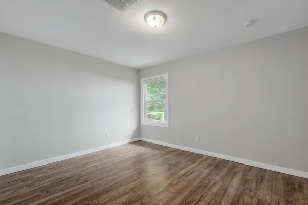 wooden floor in an empty room with a window