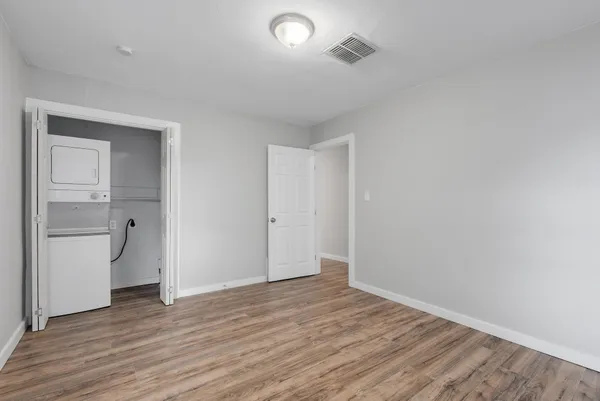 a view of an empty room with closet and a window
