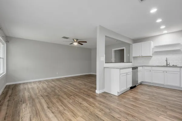 a view of a kitchen with wooden floor and electronic appliances