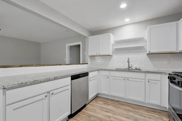 a kitchen with granite countertop white cabinets and white appliances