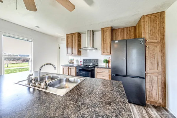 a kitchen with a refrigerator and a stove top oven