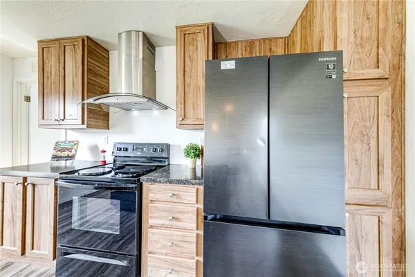 a kitchen with stainless steel appliances granite countertop a refrigerator and a stove