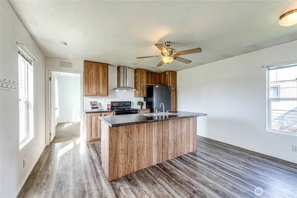 a kitchen with stainless steel appliances a sink cabinets and wooden floor