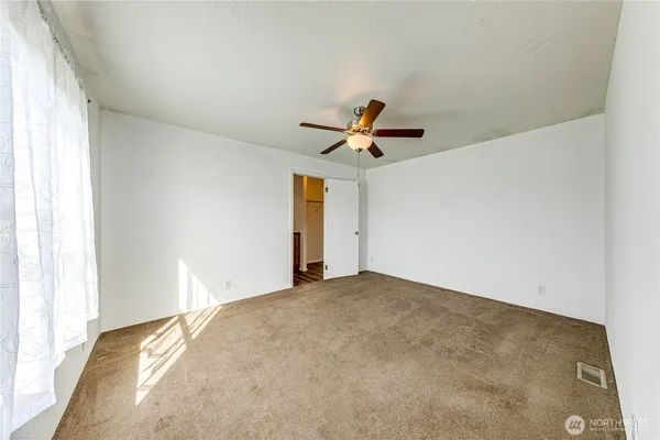 a view of a livingroom with a ceiling fan and window