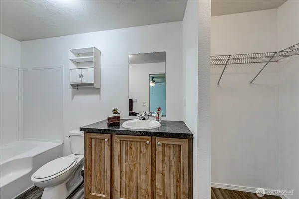a bathroom with a granite countertop sink toilet a mirror and shower