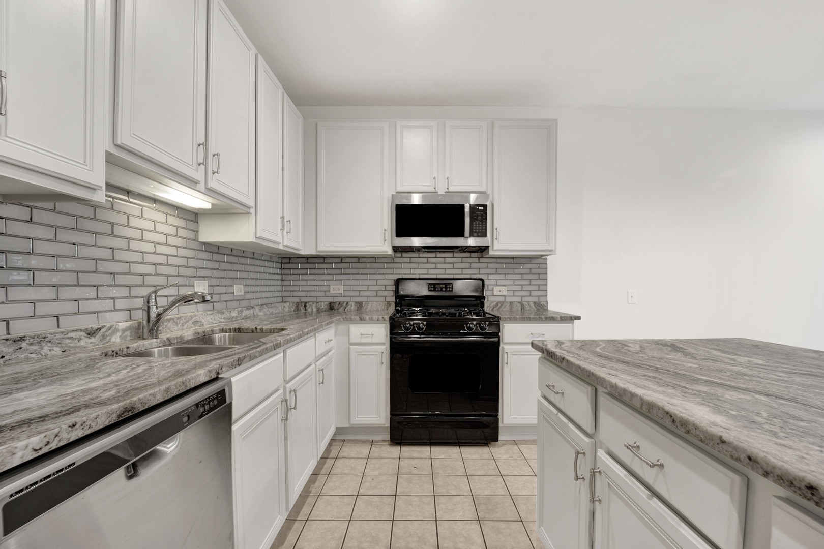 948 West 15th Place, Unit 1B Chicago, IL 60608 - Photo 11 of 59 a kitchen with stainless steel appliances granite countertop a sink stove and microwave