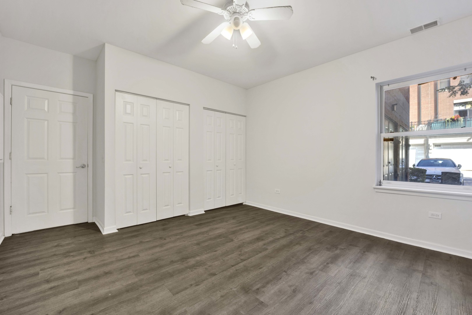 948 West 15th Place, Unit 1B Chicago, IL 60608 - Photo 13 of 59 a view of an empty room with wooden floor and a window