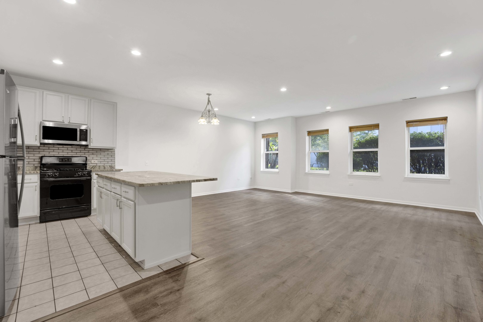 948 West 15th Place, Unit 1B Chicago, IL 60608 - Photo 5 of 59 a large kitchen with stainless steel appliances granite countertop a large counter top and a stove top oven