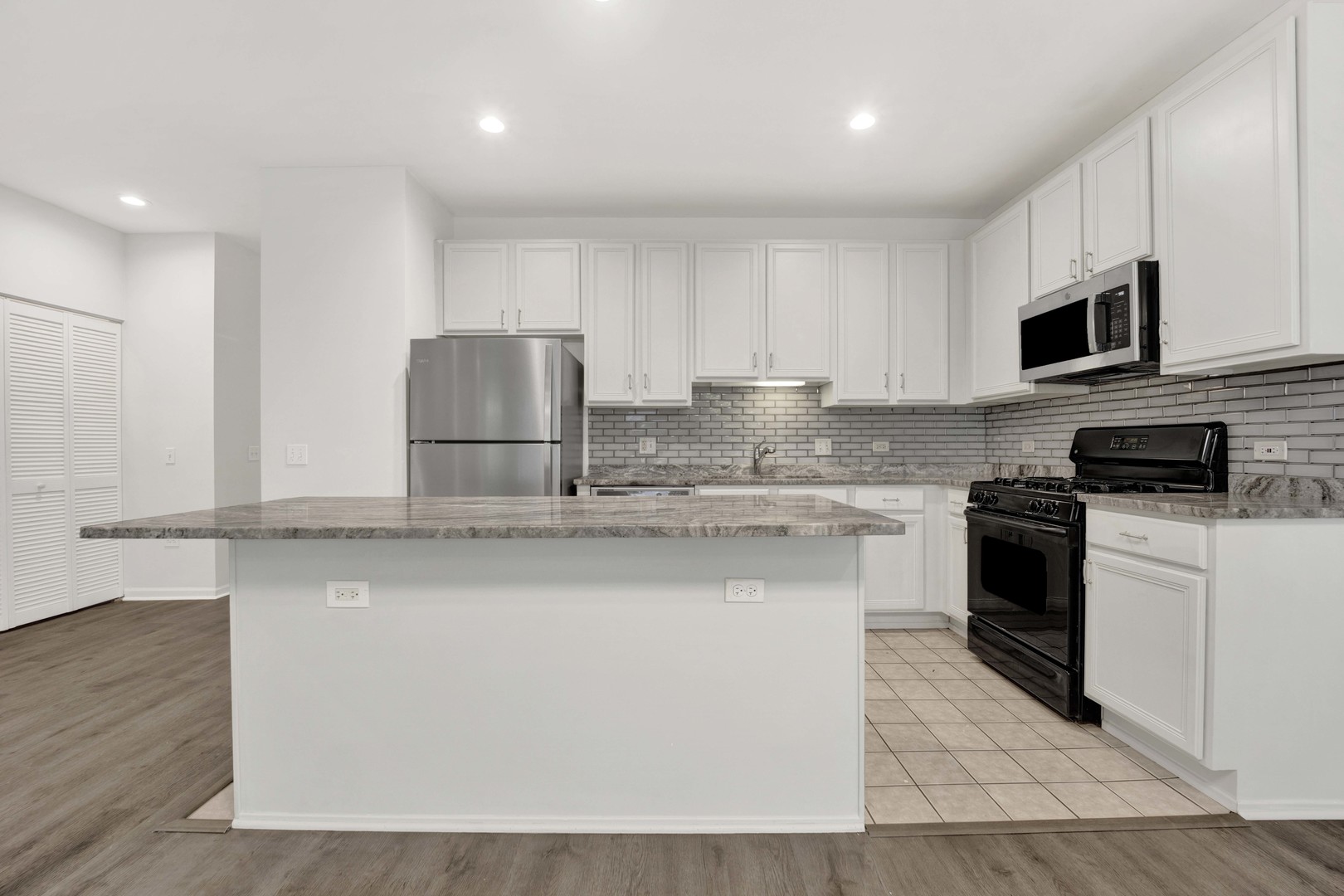 948 West 15th Place, Unit 1B Chicago, IL 60608 - Photo 10 of 59 a kitchen with stainless steel appliances granite countertop a stove a sink and a microwave
