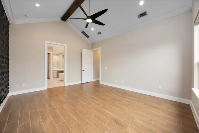 an empty room with ceiling fan and windows