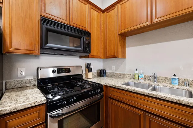 a kitchen with granite countertop a stove and a microwave