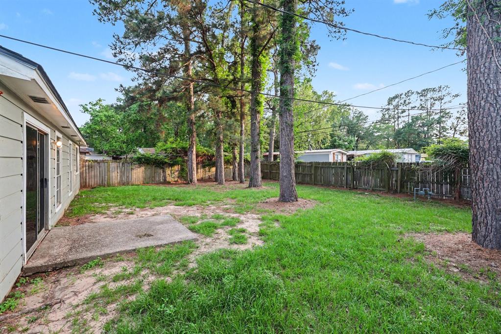 1321 North 7th Street Conroe, TX 77301 - Photo 16 of 17 a view of a yard with a house and a large tree