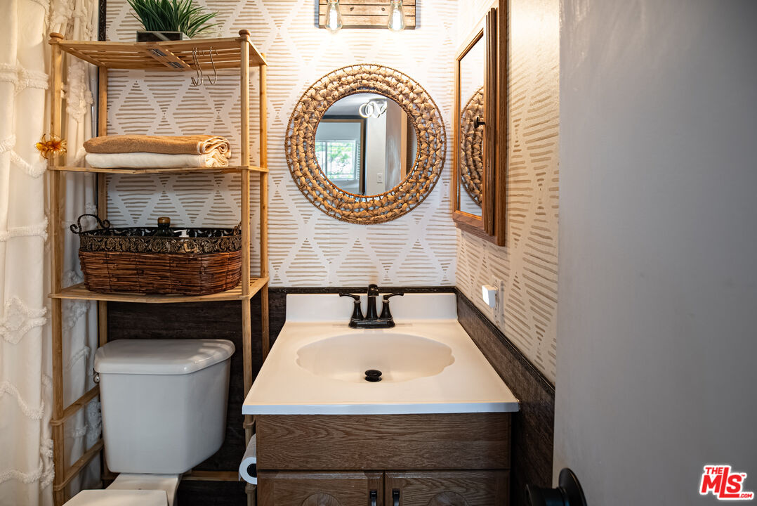 27003 Rio Prado Drive Valencia, CA 91354 - Photo 25 of 40 a bathroom with a sink a mirror and a toilet