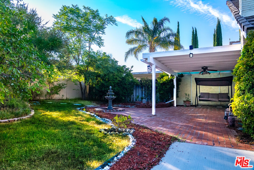 27003 Rio Prado Drive Valencia, CA 91354 - Photo 34 of 40 a view of a patio with table and chairs potted plants and large tree