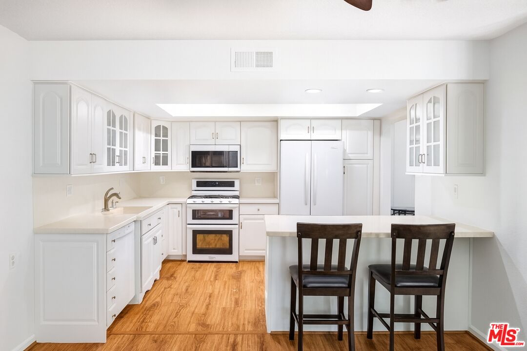 27003 Rio Prado Drive Valencia, CA 91354 - Photo 7 of 40 a kitchen with a table chairs refrigerator and cabinets