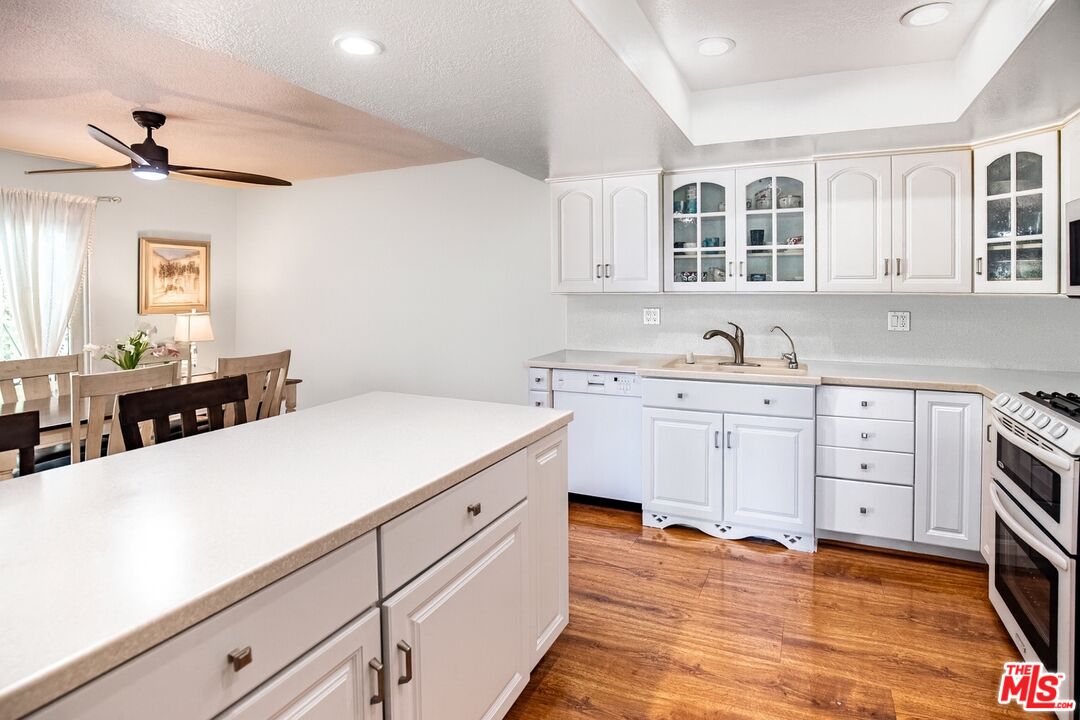 27003 Rio Prado Drive Valencia, CA 91354 - Photo 9 of 40 a kitchen with sink cabinets and wooden floor