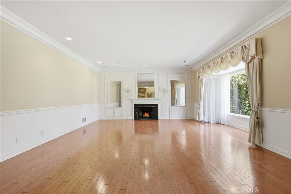 960 Hampton Road Arcadia, CA 91006 - Photo 5 of 28 an empty room with wooden floor fireplace and windows