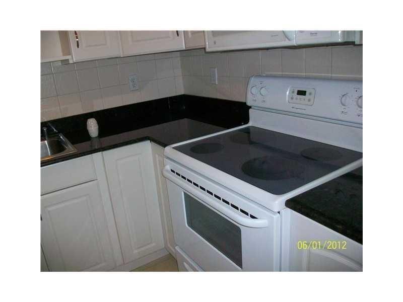 505 Northeast 20th Avenue, Unit 118 Deerfield Beach, FL 33441 - Photo 3 of 22 a kitchen view of a cabinets and stove