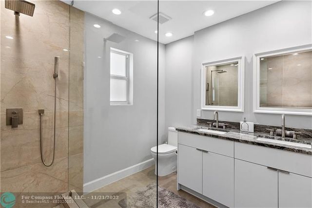 a bathroom with a double vanity sink mirror and shower