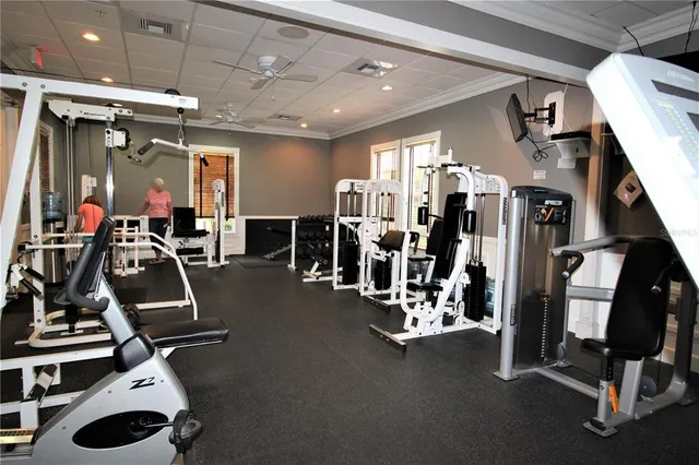 an empty room with wooden floor fireplace and windows