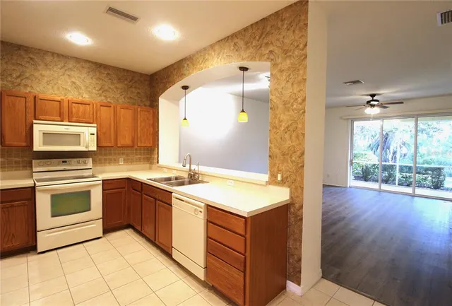 a large kitchen with stainless steel appliances granite countertop a stove and a sink