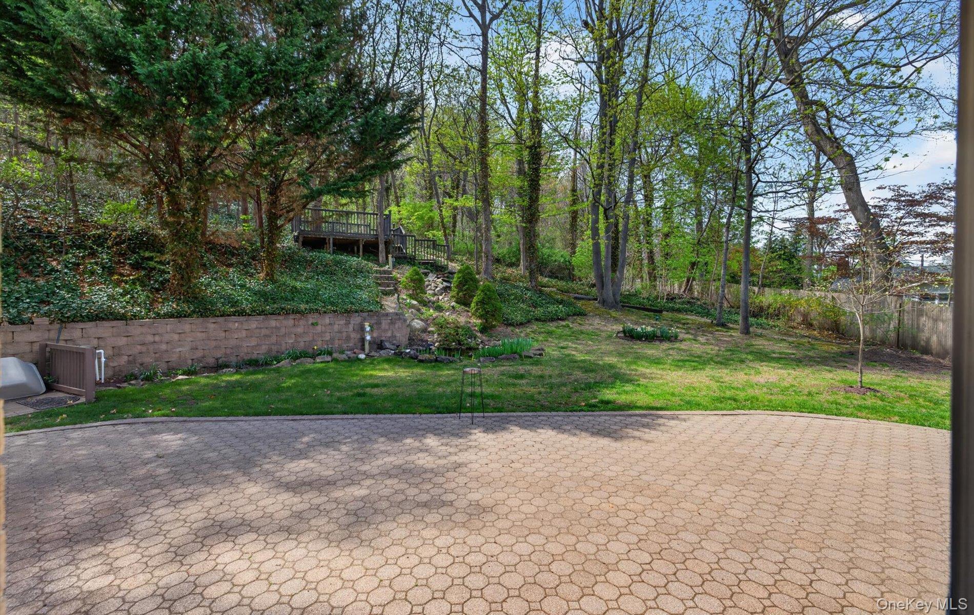 16 East Slope Road Bayville, NY 11709 - Photo 41 of 48 Spacious paver patio with a terraced, wooded backyard