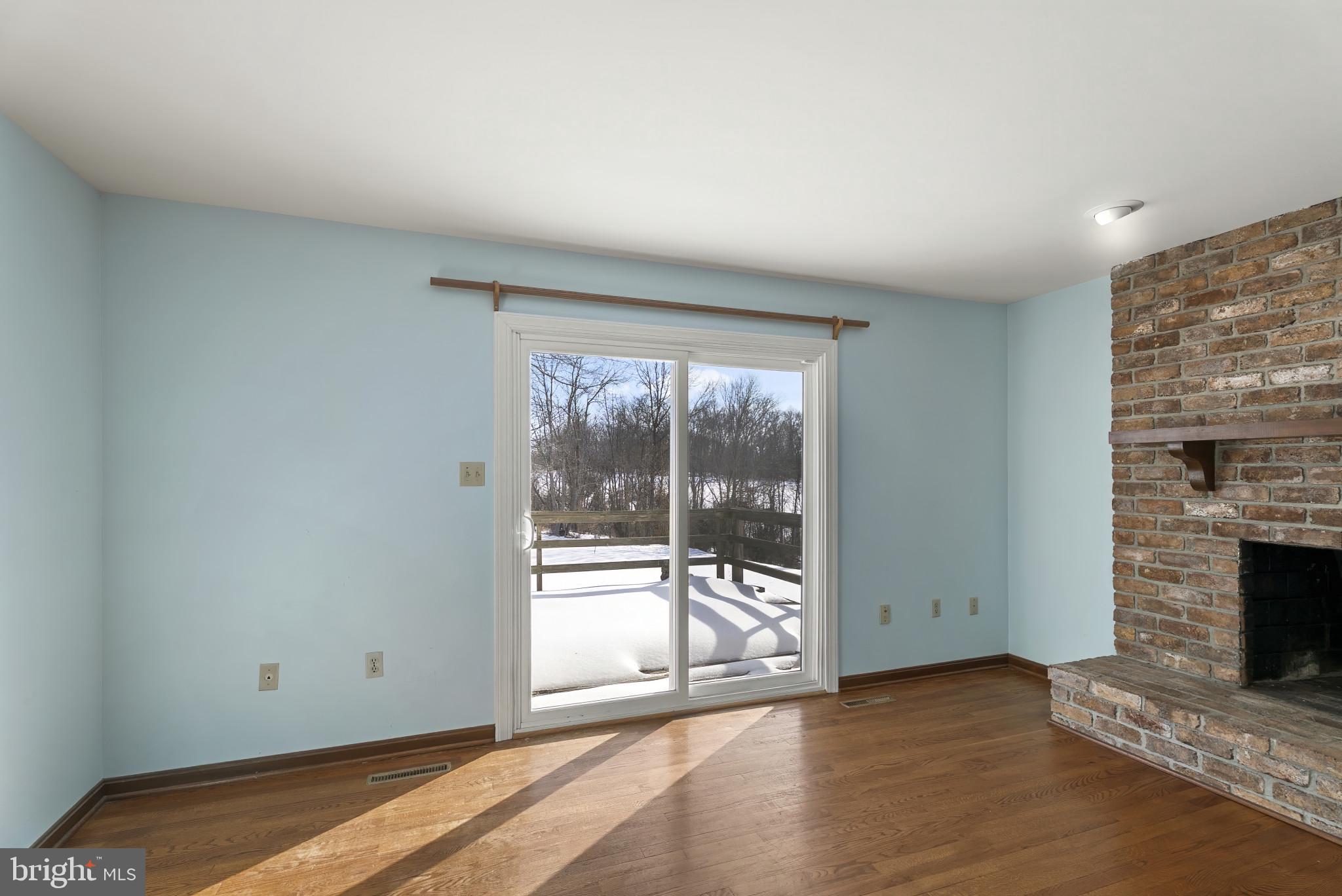 7823 Timmons Road Mount Airy, MD 21771 - Photo 13 of 38 an empty room with wooden floor and fireplace
