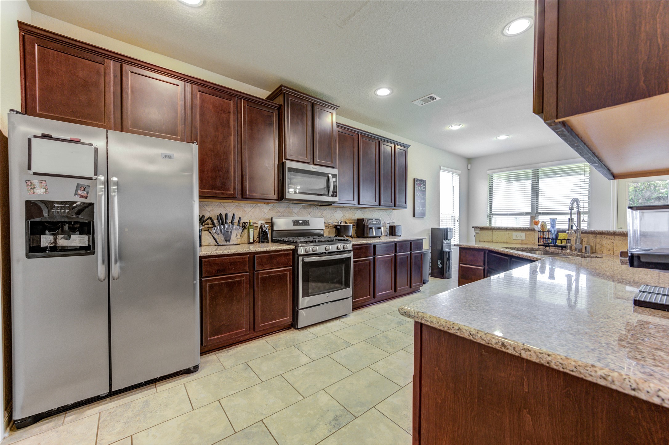 24511 Stratton Creek Drive Spring, TX 77373 - Photo 11 of 27 The well-designed kitchen features granite countertops, a gas range, abundant cabinet storage, and generous prep space for everyday cooking.