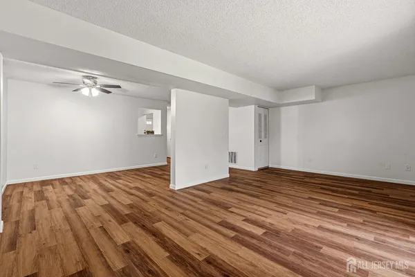 a view of an empty room and wooden floor
