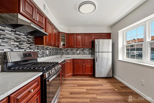 a kitchen with stainless steel appliances granite countertop a stove a sink dishwasher a refrigerator and a stove