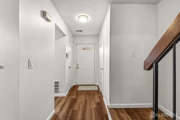a view of a hallway with wooden floor and staircase
