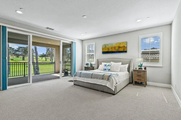 a spacious bedroom with a bed and a large window