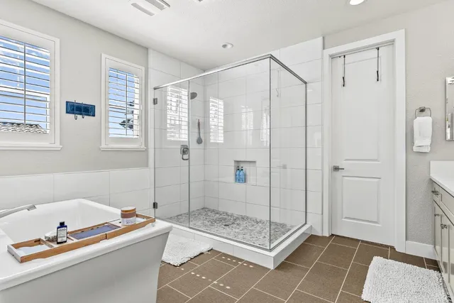 a bathroom with a granite countertop bathtub shower sink and mirror