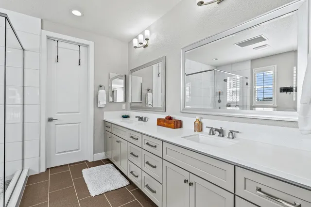 a bathroom with double vanity sink and mirror