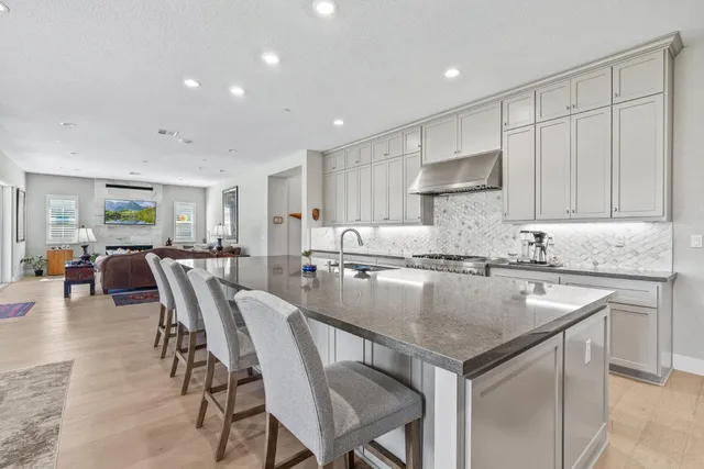a kitchen with a dining table chairs sink and cabinets