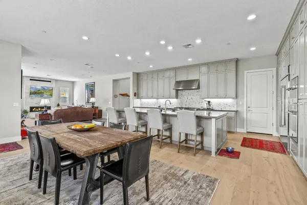 a kitchen with a dining table chairs and refrigerator