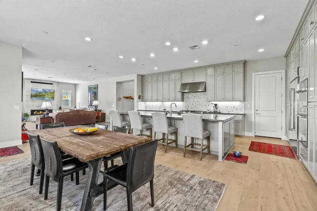 a kitchen with a dining table chairs and refrigerator
