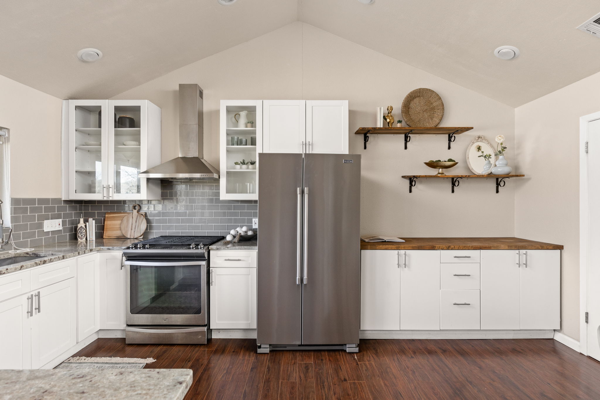 6502 Highpoint Cove Austin, TX 78723 - Photo 15 of 40 Kitchen featuring white cabinets, stainless steel appliances, open shelves, dark wood-style floors, and vaulted ceiling