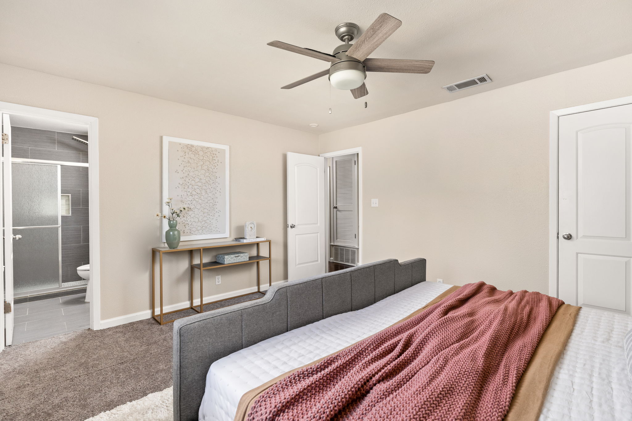 6502 Highpoint Cove Austin, TX 78723 - Photo 23 of 40 Bedroom with carpet floors, ceiling fan, and connected bathroom