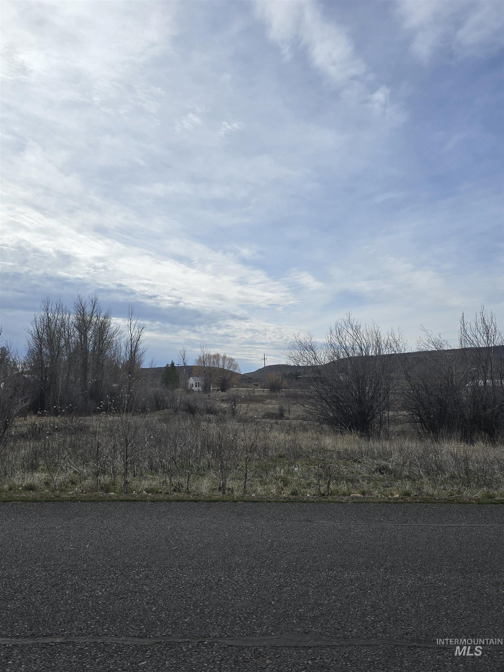 View of asphalt road featuring a view of rural / pastoral area