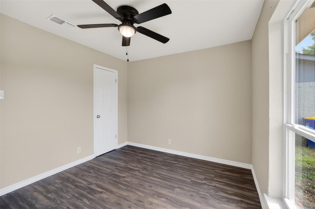 7528 Meadowlark Lane North Watauga, TX 76148 - Photo 13 of 31 a view of a room with wooden floor and a ceiling fan