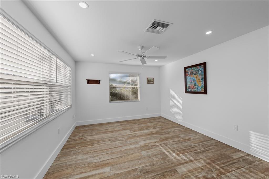 849 Beach Road Sanibel, FL 33957 - Photo 14 of 27 wooden floor in an empty room with a window