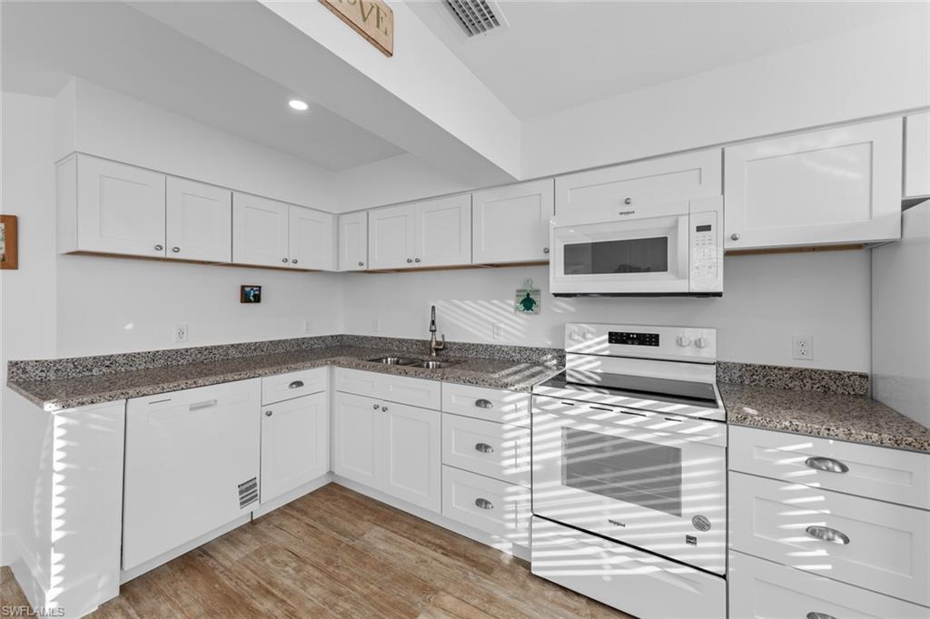 849 Beach Road Sanibel, FL 33957 - Photo 8 of 27 a kitchen with granite countertop a sink a stove and cabinets