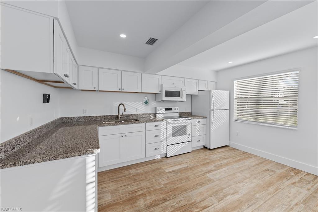 849 Beach Road Sanibel, FL 33957 - Photo 10 of 27 a large kitchen with granite countertop a sink stainless steel appliances and cabinets