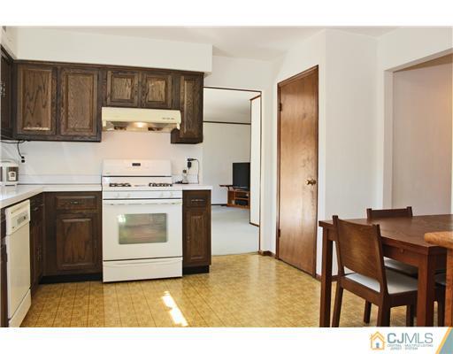 93 South Cliff Road Colonia, NJ 07067 - Photo 16 of 25 a kitchen with stainless steel appliances granite countertop a stove a refrigerator and a sink with wooden cabinets