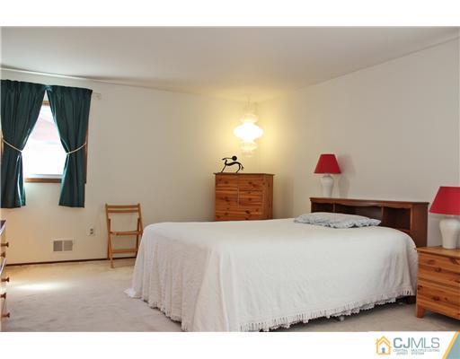 93 South Cliff Road Colonia, NJ 07067 - Photo 22 of 25 a bedroom with a bed and a flat tv screen on dresser