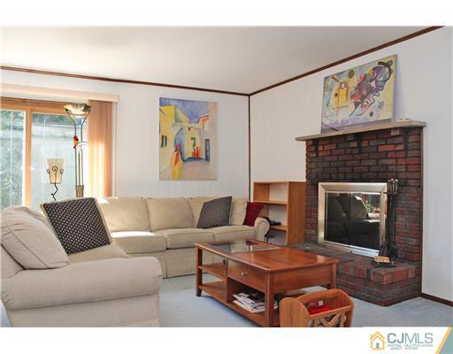 93 South Cliff Road Colonia, NJ 07067 - Photo 5 of 25 a living room with furniture a table and a fireplace