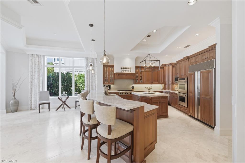361 Pirates Bight Naples, FL 34103 - Photo 10 of 45 a large kitchen with a table and chairs