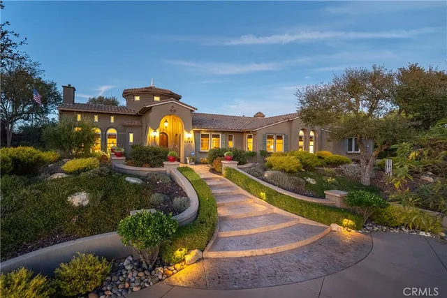 a view of a house with a yard and potted plants